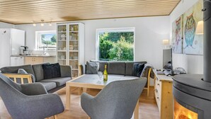Una sala de estar moderna con un sofá, sillas, una mesa de centro y una chimenea.