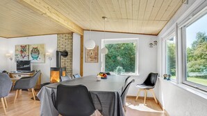 Un comedor moderno con una mesa grande, sillas y vistas a zonas verdes.