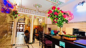 A hotel lobby with a marble floor, a reception desk, and a seating area with chairs and a table. - Hotel Moon Light Palace Jaipur (Jaipur)