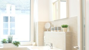 A bathroom with a sink, mirror, and potted plants. - Apartment in the heart of Boppard (Boppard)