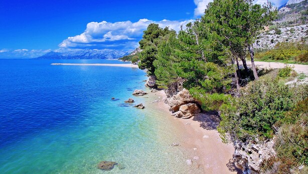 A coastal landscape with clear blue waters, a sandy beach, and rocky terrain with trees. - Modern Villa Nera with pool and sea view, three bedrooms 6+2 people (Makarska)