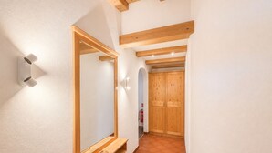 A hallway with a wooden bench, a mirror, and a wardrobe.