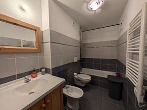 Ein modernes Badezimmer mit Waschbecken, Bidet, Toilette und Badewanne.