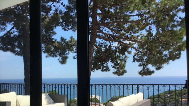 Un balcon avec un canapé et vue sur la mer.