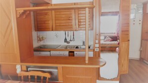 Una cucina compatta con mobili in legno, un lavello e una lavastoviglie.