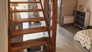 A wooden staircase with a handrail, leading to a room with a bed, a small table, and a shelf. - Gîte near Chambord - 6/7 people (Maslives)