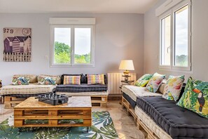 Un salon avec un canapé d’angle, une table basse et une lampe.