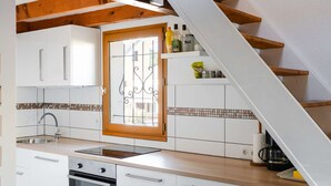 A modern kitchen with white cabinets, a stainless steel sink, and a wooden staircase. - Studio mezzanine with pool, parking, Narbonne-Plage (Narbonne-Narbonne Plage-Narbonne Plage)
