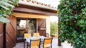 An outdoor patio with a table set for two, surrounded by chairs, and a wooden pergola overhead. - Studio mezzanine with pool, parking, Narbonne-Plage (Narbonne-Narbonne Plage-Narbonne Plage)
