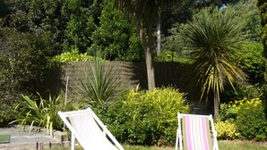 Two white lounge chairs with striped cushions in a garden setting. - TRIDILLE 1 - Apartment for rent with garden in Carnac - D6 (Carnac)