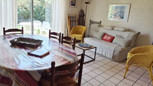 A dining area with a round table, chairs, and a sofa. - KREISKER 2 - Maison Jumelée, Jardin - CA6008 (Carnac)