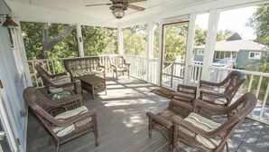 A covered porch with wicker furniture and a ceiling fan.