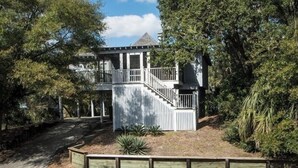 A two-story house with a balcony and a staircase leading to the upper floor.
