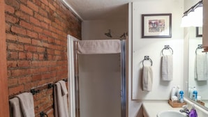 Une salle de bain avec une douche, un lavabo et un miroir.