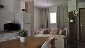 A compact living space with a kitchenette, a dining area, and a bed. - Charming apartment with large terrace and private pool 5 minutes from the beach (Santa-Lucia-Di-Moriani)