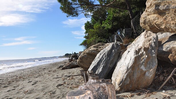 A beach with large rocks, a wooden post, and a fence. - Charming apartment with large terrace and private pool 5 minutes from the beach (Santa-Lucia-Di-Moriani)