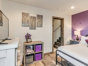 Un dormitorio con cama, escritorio, silla, armario y escalera.