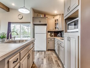 A kitchen with a built-in refrigerator, a microwave, and a sink.