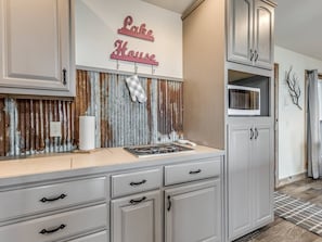 A kitchen with a stove, cabinets, and a sign that reads 'Lake House.'