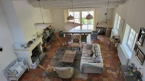 Ein geräumiges Wohnzimmer mit Kamin, Esstisch und einer Couch.