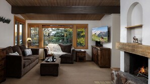 A cozy living room with a fireplace, a television, and a comfortable seating area. - Aspenwood L10 - Walk to Slopes | Cozy Mountain + Hot Tub (Snowmass Village)