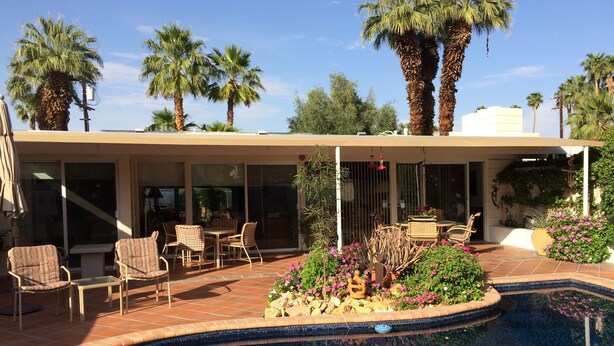 A pool area with a patio, chairs, and a small garden with flowers and plants. - Location, location, location!  El Paseo Jewel in the desert  (Palm Desert)