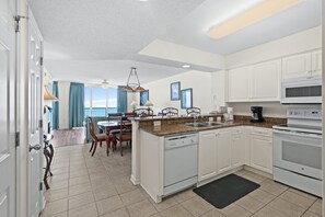 Enjoy meals in the kitchen with a dishwasher and microwave, adjacent to a dining area with a table and chairs.