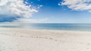 Une plage avec un ciel dégagé et une mer calme.