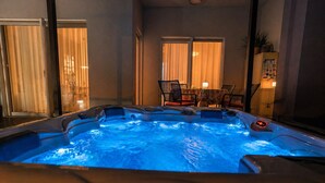 A hot tub with a digital control panel, a table with chairs, and a window with curtains. - Deluxe beach suite with hot tub, 2 minutes away from the beach (Split)