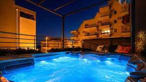A swimming pool with hot tubs, surrounded by a metal fence, and adjacent to a building with balconies. - Deluxe beach suite with hot tub, 2 minutes away from the beach (Split)