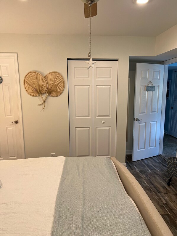 Un dormitorio con cama, armario y una puerta con un letrero.