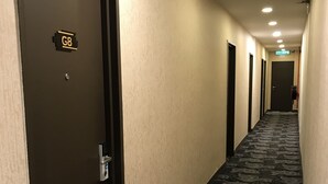 A hotel hallway with a carpeted floor, a door labeled 'G8', and a sign indicating the direction to the lobby. - Victory Hotel (Johor Bahru)