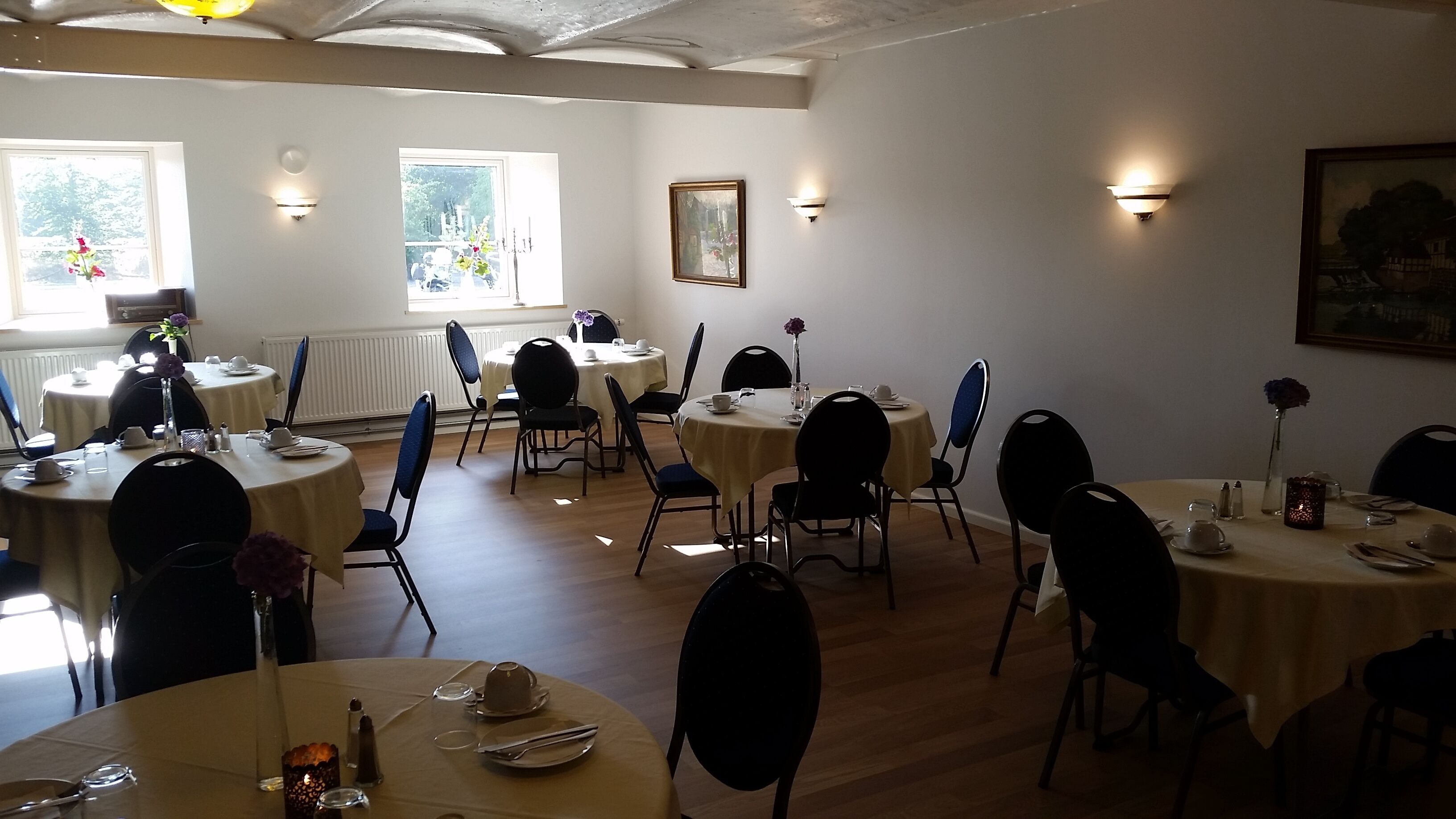 A dining area with round tables, chairs, and table settings.