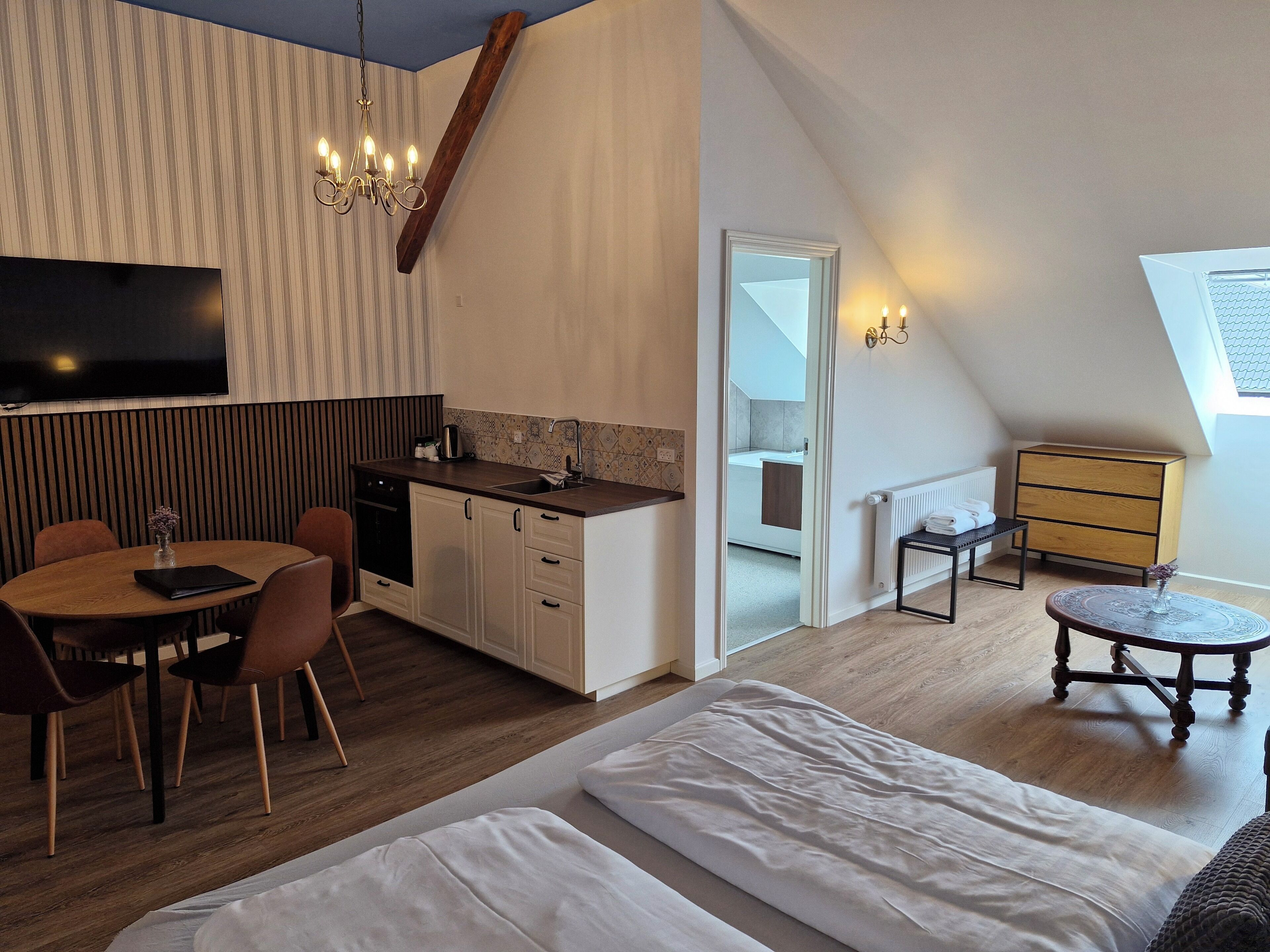 A modern loft apartment with a kitchen, dining area, and a bedroom.