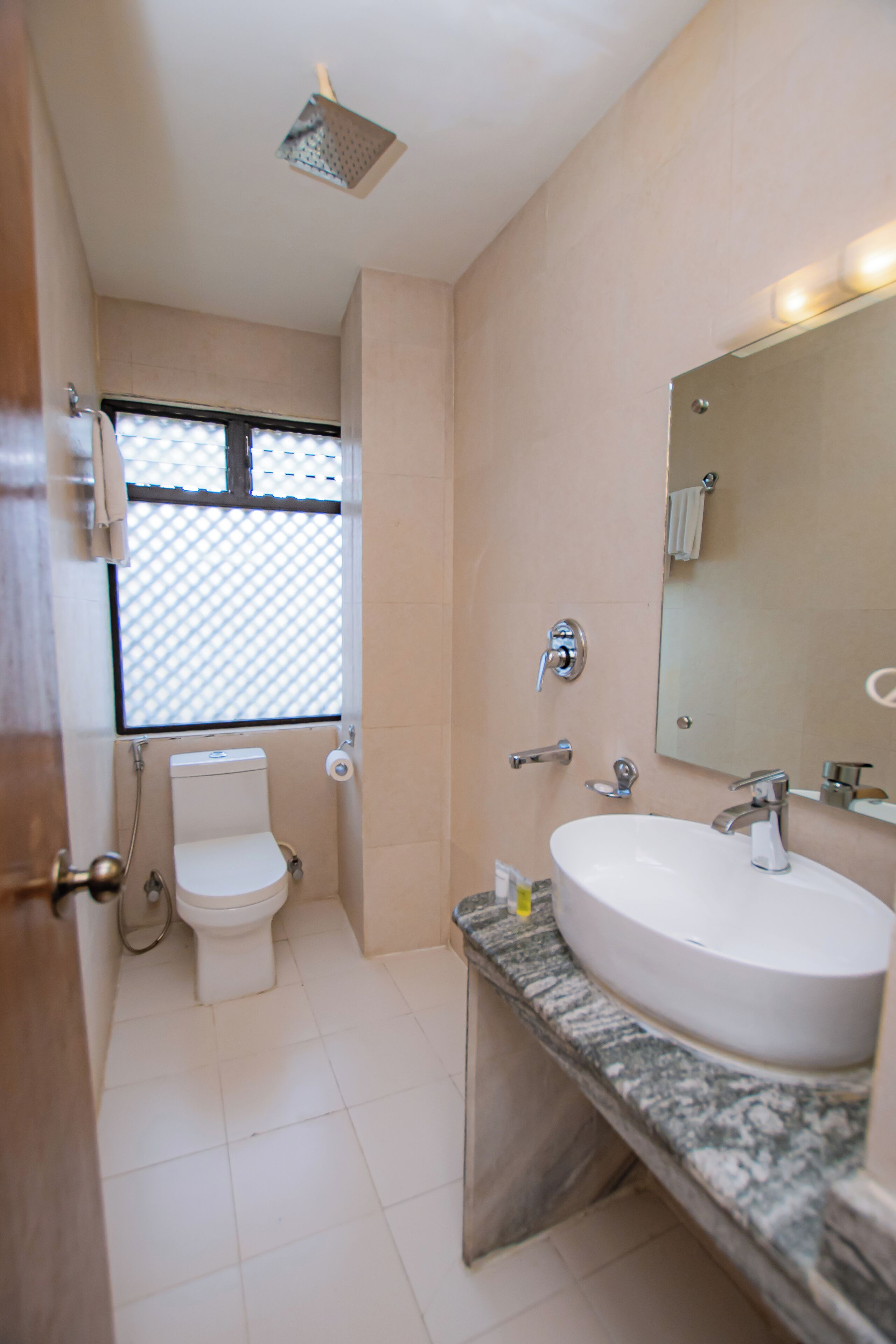 A bathroom with a toilet, sink, and mirror.