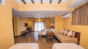 A hotel room with two single beds, a wooden floor, a desk, and a TV. - Pokhara Boutique Hotel (Pokhara)