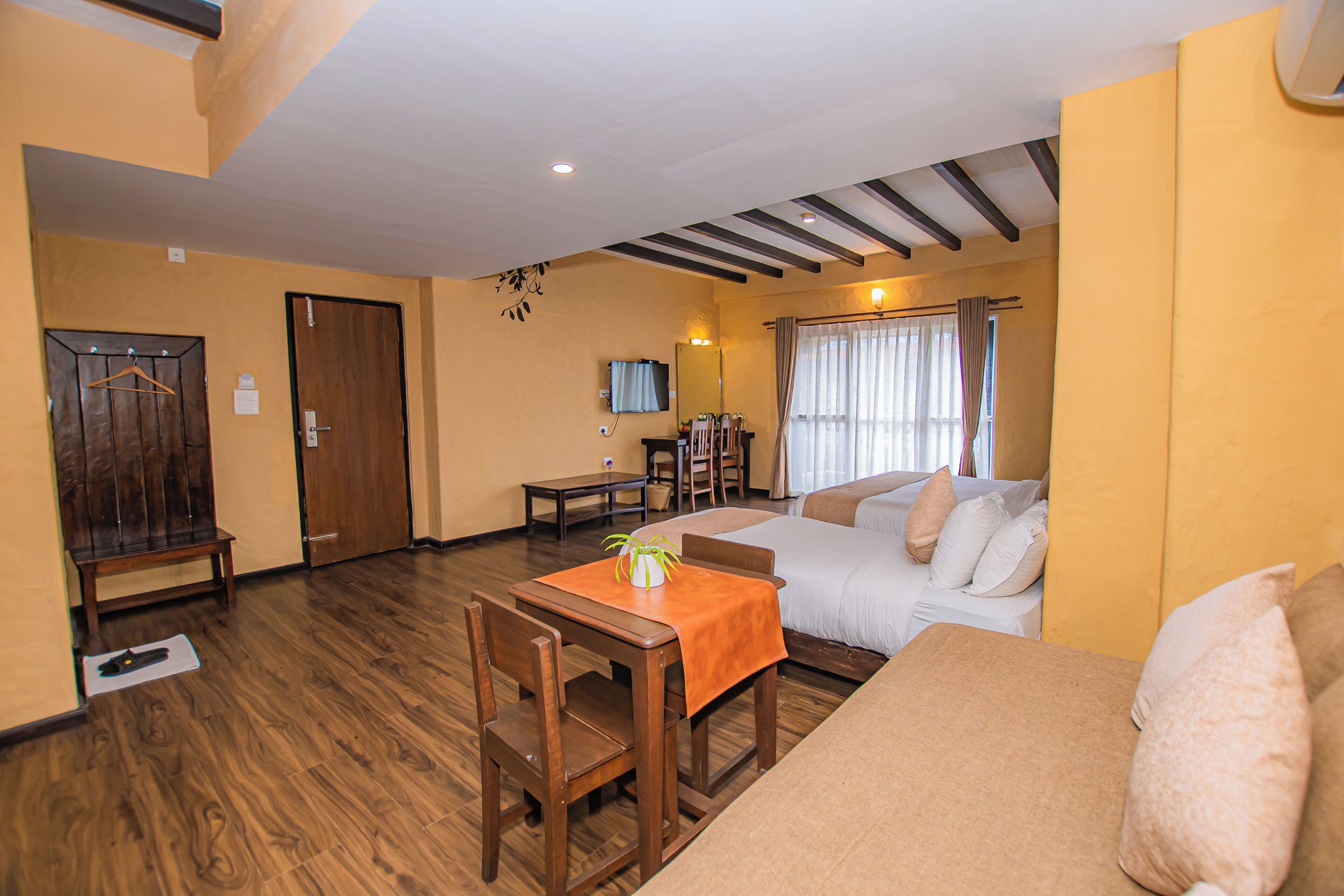 A room with a bed, a sofa, a dining table, and a TV.