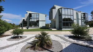 A modern two-story building with large windows and a symmetrical design. - Blue Avenue (Kassandra)