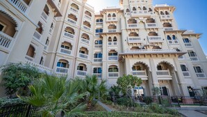 Ein mehrstöckiges Hotel mit Balkonen, einem Innenhof und üppigem Grün.