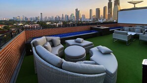 A rooftop terrace with a city skyline view, outdoor seating, and a small pool. - Erian Hotel (Jakarta)