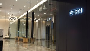 A modern hotel interior with glass walls, a reception area, and a visible "SIAN" sign. - Erian Hotel (Jakarta)