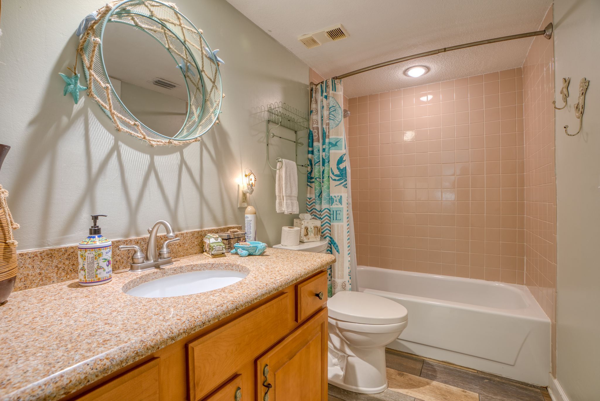 A bathroom with a sink, mirror, toilet, and bathtub.