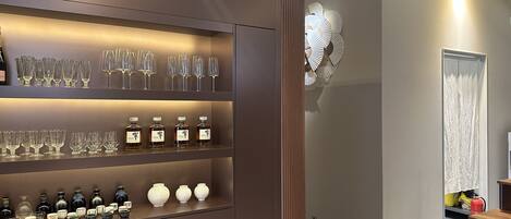 Un interior moderno con una vitrina empotrada que exhibe cristalería y botellas.
