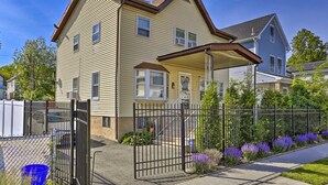 A two-story house with a front porch, a fenced yard, and a driveway. - Charming One Family Colonial Home / Business . (East Orange)