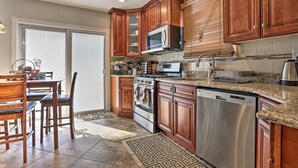 A kitchen with wooden cabinets, a microwave, a stove, and a dishwasher. - Charming One Family Colonial Home / Business . (East Orange)