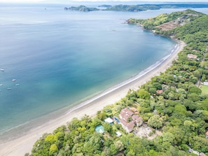 Enjoy a serene beachfront setting surrounded by lush greenery and a swimming pool.