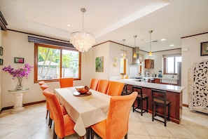 Enjoy meals in the kitchen with a central island and bar seating, surrounded by artwork and a large window.