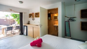 A hotel room with a bed, a small kitchenette, a bathroom, and a dining area with a table and chairs. - 'Boutique' studio 'Dushi Bida' (Willemstad)
