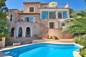 A two-story house with a swimming pool, a balcony, and a staircase leading to the upper floor. - Charming Villa with Sea Views & Pool (Andratx)