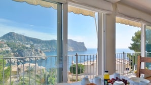 A balcony with breakfast setup overlooking a coastal landscape. - Charming Villa with Sea Views & Pool (Andratx)